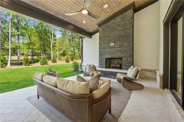 view of patio / terrace featuring an outdoor living space with a fireplace and a ceiling fan