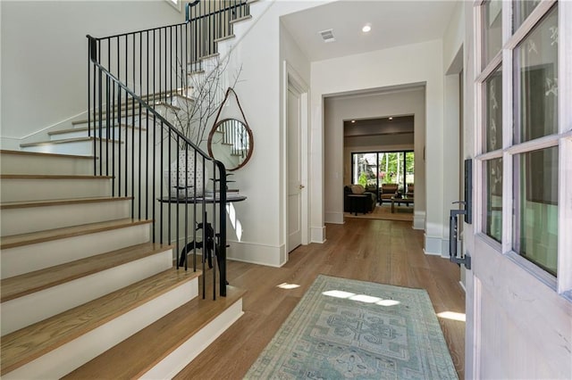 foyer with visible vents, recessed lighting, stairway, wood finished floors, and baseboards