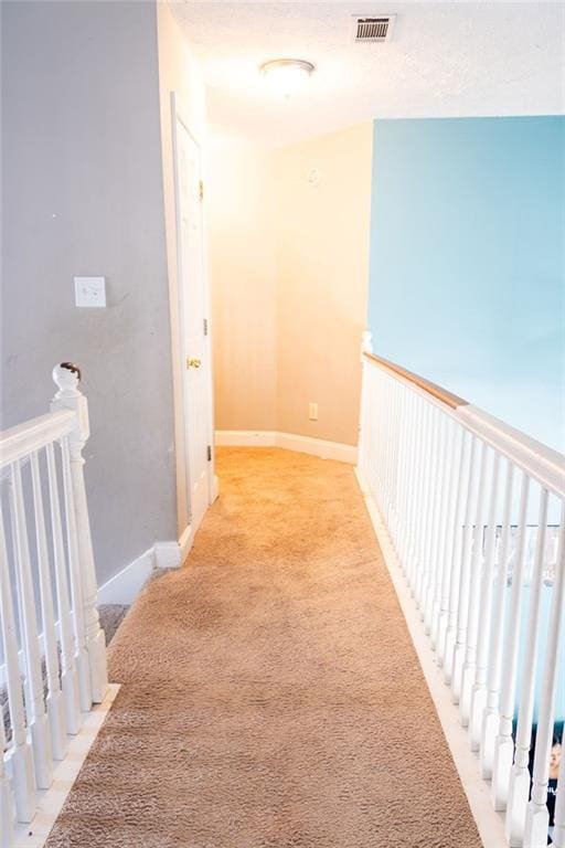 hallway featuring light colored carpet