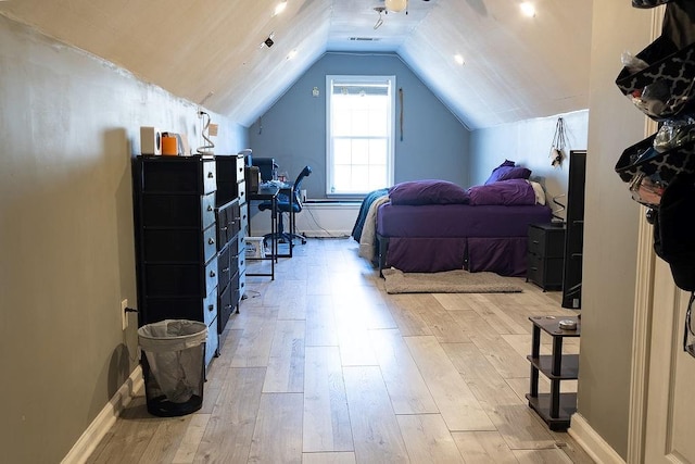 bedroom with vaulted ceiling and light wood-type flooring