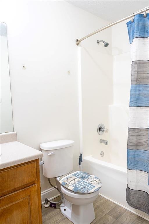 full bathroom featuring vanity, hardwood / wood-style floors, shower / bath combination with curtain, and toilet