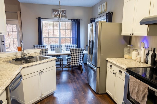 kitchen with white cabinetry, appliances with stainless steel finishes, sink, and decorative light fixtures