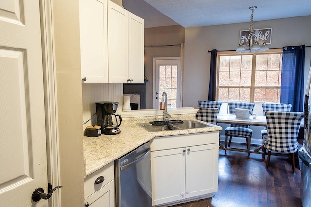 kitchen with pendant lighting, sink, white cabinetry, plenty of natural light, and stainless steel dishwasher