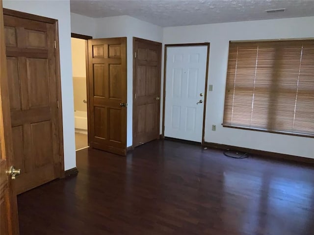 entrance foyer featuring a textured ceiling and dark wood-type flooring