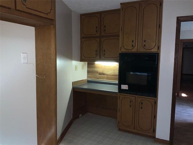 kitchen featuring tasteful backsplash and black oven