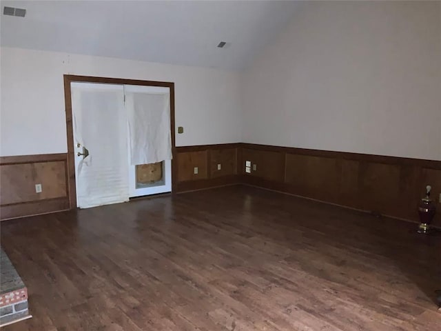 empty room with dark hardwood / wood-style floors and lofted ceiling