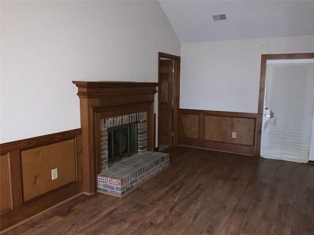 unfurnished living room with a fireplace, dark hardwood / wood-style flooring, and vaulted ceiling