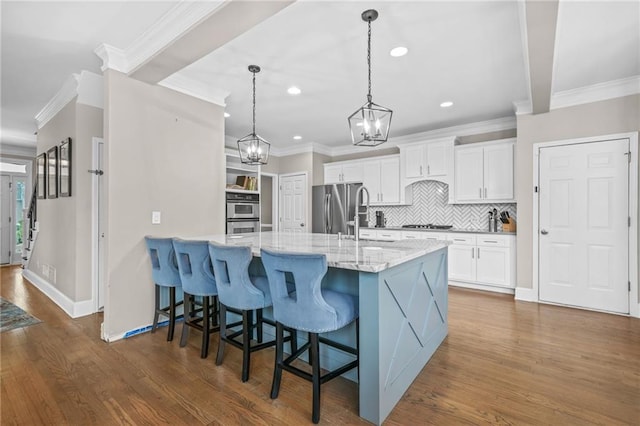 kitchen with stainless steel appliances, dark wood-type flooring, a kitchen breakfast bar, and white cabinetry