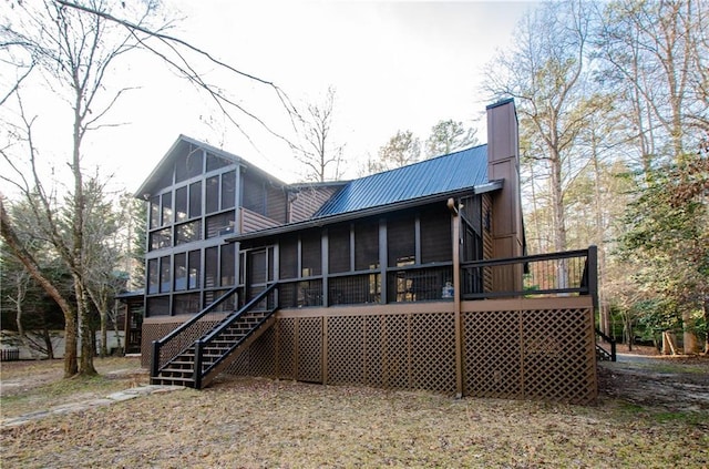 back of house featuring a sunroom and a wooden deck