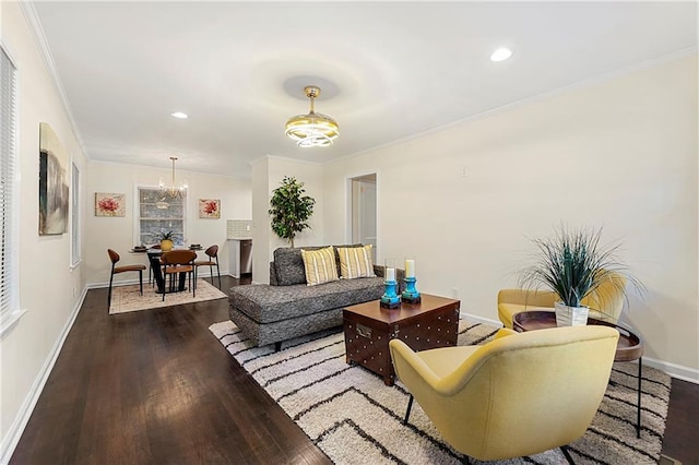 living room featuring dark hardwood / wood-style floors, crown molding, and an inviting chandelier