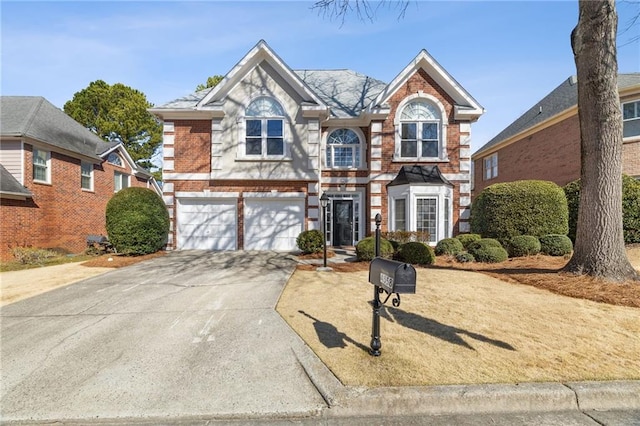 view of front facade with brick siding, driveway, and an attached garage