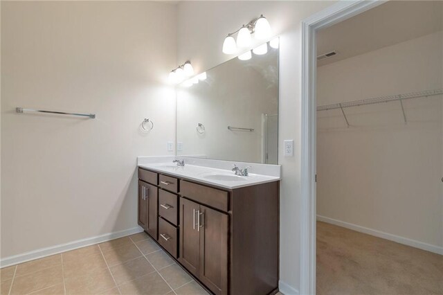 bathroom with tile patterned floors and dual vanity