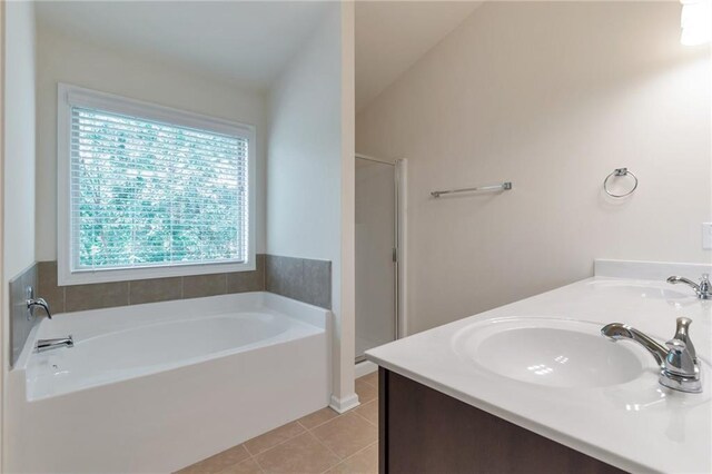 bathroom featuring a bathing tub, double vanity, and tile patterned floors