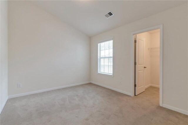 empty room with light carpet and lofted ceiling