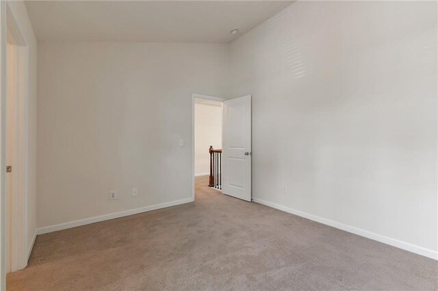 carpeted empty room featuring high vaulted ceiling