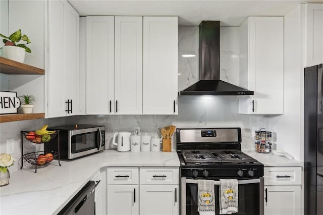 kitchen with decorative backsplash, stainless steel appliances, white cabinetry, open shelves, and wall chimney range hood