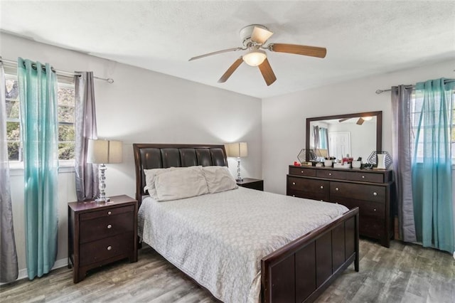 bedroom featuring light wood-style flooring, ceiling fan, and a textured ceiling