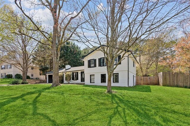 split level home with fence and a front lawn
