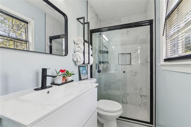 full bathroom featuring toilet, a marble finish shower, and a wealth of natural light