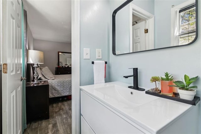 ensuite bathroom featuring ensuite bathroom, wood finished floors, and vanity