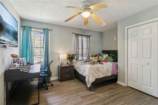 bedroom featuring a textured ceiling, baseboards, ceiling fan, and wood finished floors