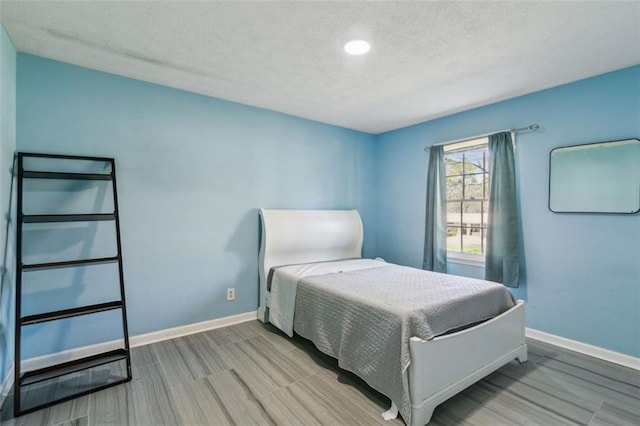 bedroom featuring baseboards and a textured ceiling