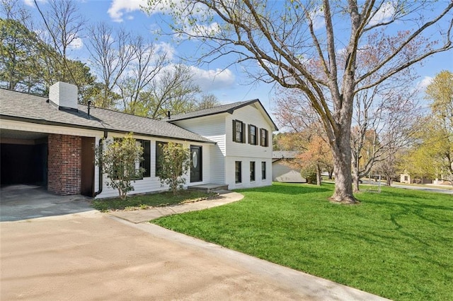 view of side of property with a lawn, concrete driveway, and a carport