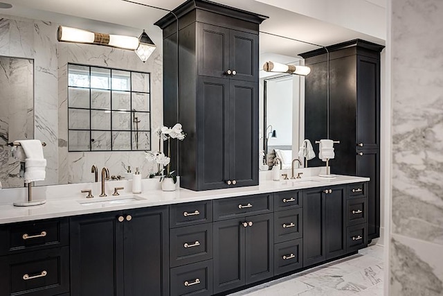 bathroom featuring marble finish floor, a sink, and double vanity