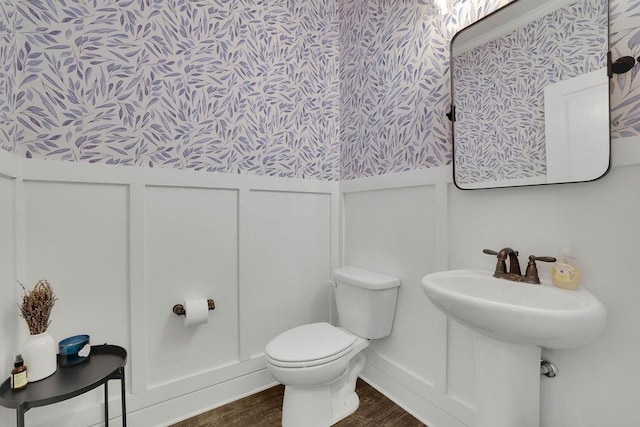 7190 Tributary Ct, Cumming, GA 30040 - bathroom featuring a decorative wall, wood finished floors, wainscoting, toilet, and wallpapered walls