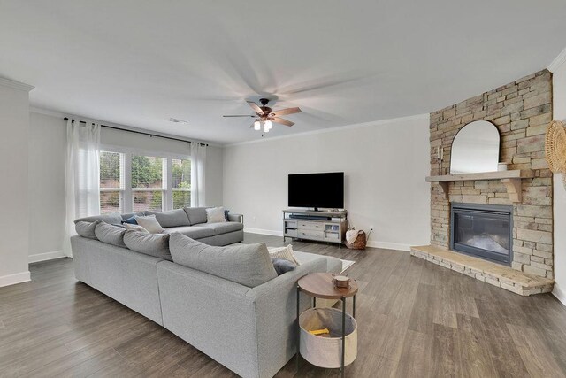 7190 Tributary Ct, Cumming, GA 30040 - living area featuring ornamental molding, ceiling fan, baseboards, a stone fireplace, and wood finished floors
