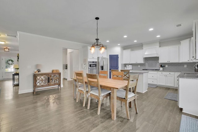 7190 Tributary Ct, Cumming, GA 30040 - dining room with crown molding, light wood-style flooring, recessed lighting, and baseboards