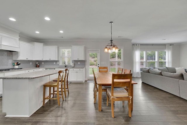 7190 Tributary Ct, Cumming, GA 30040 - dining space featuring ornamental molding, a chandelier, healthy amount of natural light, recessed lighting, and wood finished floors