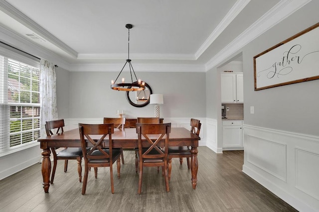 7190 Tributary Ct, Cumming, GA 30040 - dining area featuring dark wood-style floors, a wainscoted wall, crown molding, a chandelier, and a decorative wall