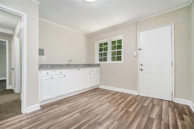 kitchen featuring white cabinets, light wood-type flooring, and light stone countertops