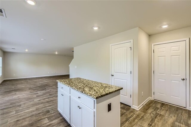 kitchen with white cabinets, baseboards, stone countertops, and dark wood finished floors