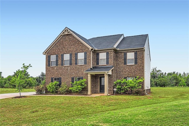 view of front facade with brick siding and a front lawn
