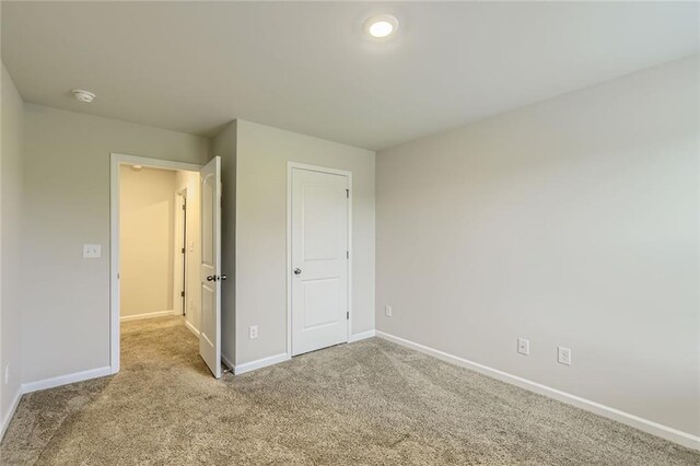 unfurnished bedroom featuring baseboards and carpet