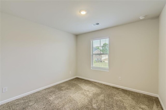 carpeted spare room with baseboards and visible vents