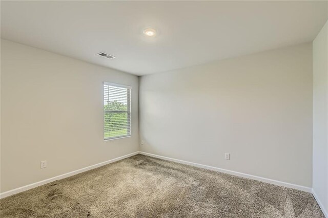 carpeted empty room with baseboards and visible vents
