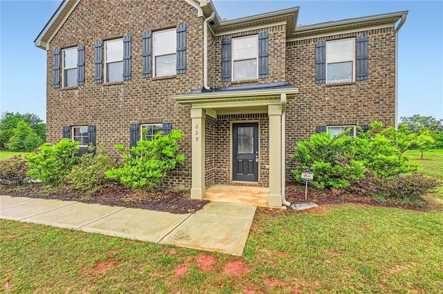view of front of home featuring a front lawn and brick siding