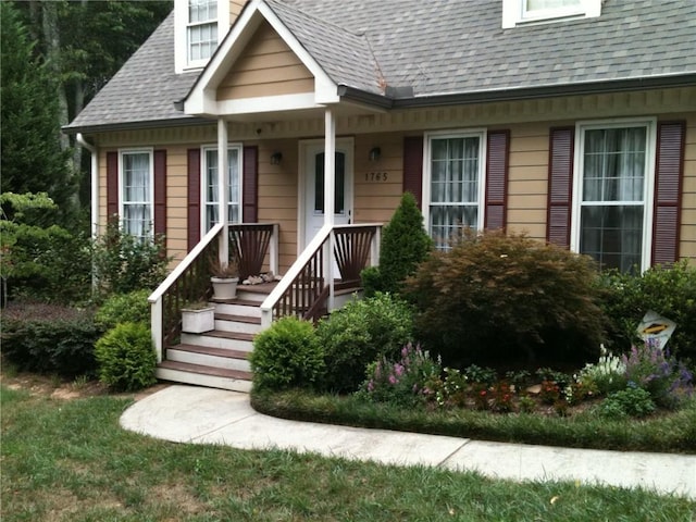 property entrance featuring roof with shingles