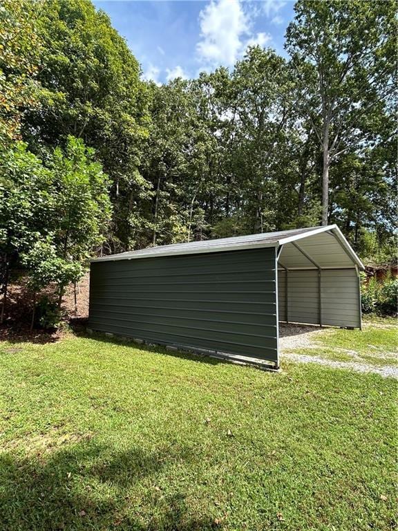 view of outbuilding featuring a carport and a yard