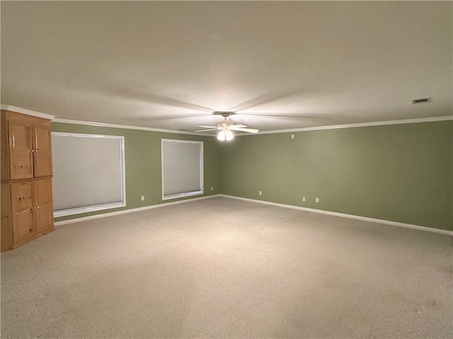 empty room featuring carpet floors, ceiling fan, and ornamental molding