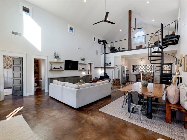 living room with visible vents, stairway, a ceiling fan, high vaulted ceiling, and concrete floors