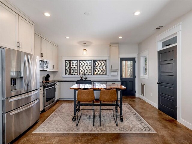 kitchen featuring concrete flooring, appliances with stainless steel finishes, plenty of natural light, and visible vents