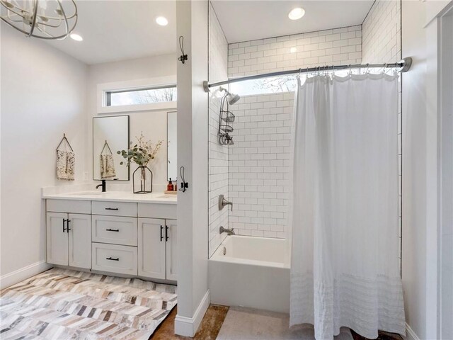 bathroom featuring baseboards, double vanity, shower / bath combination with curtain, and recessed lighting