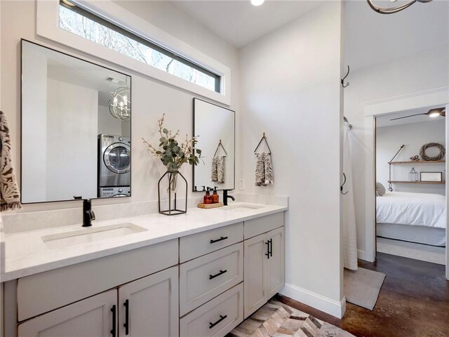 bathroom with double vanity, a sink, connected bathroom, and baseboards