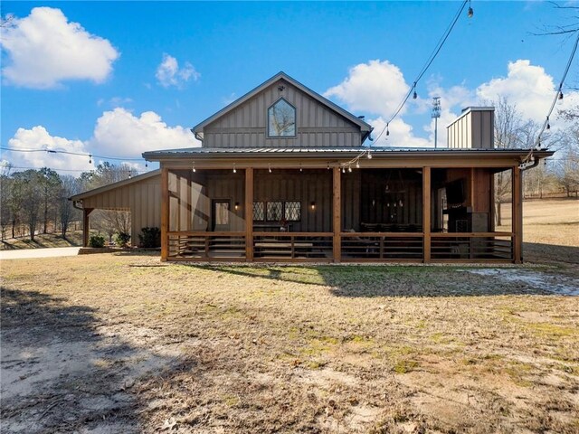 rear view of property with board and batten siding and a chimney