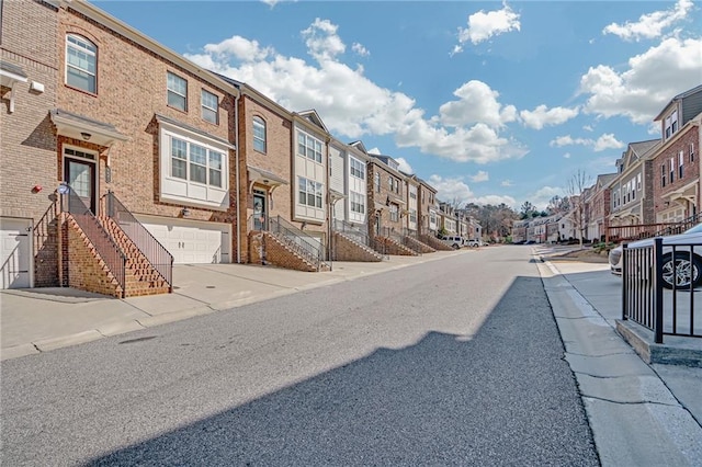 view of road featuring sidewalks, stairs, a residential view, and curbs