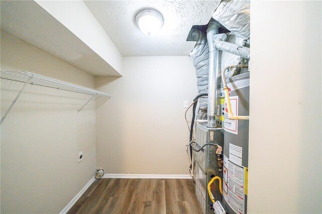 1129 Winston Dr, Decatur, GA 30032 - clothes washing area with a textured ceiling, dark hardwood / wood-style flooring, gas water heater, and electric dryer hookup